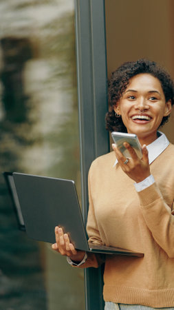 A Professional Woman Actively Engaged in Her Work While Using a Laptop and a Phone