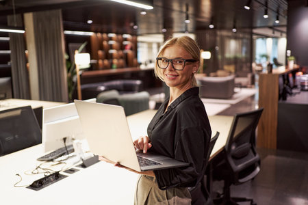 A Professional Woman Actively Engaged in Her Work Within a Contemporary Office Environmentの写真素材
