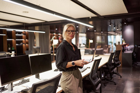 This image portrays a contemporary office environment showcasing a professional woman at workの写真素材
