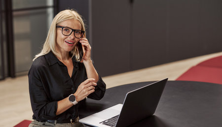 A Professional Woman is Working on Her Laptop in a Modern Office Environment Today