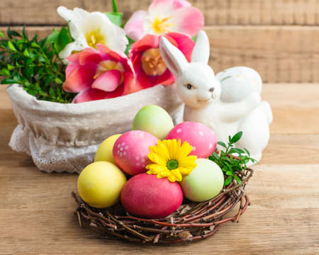 Easter eggs in nest on wooden background