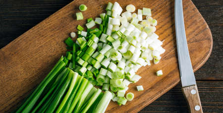 Sliced Fresh green onions on a wooden cutting board