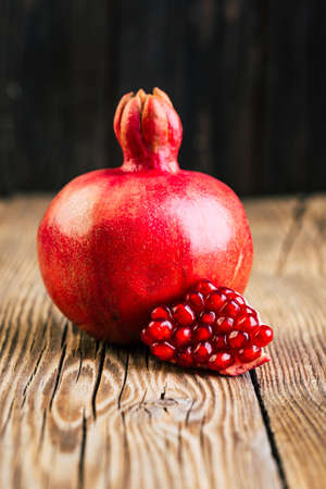 Ripe pomegranate on a wooden background, copy space