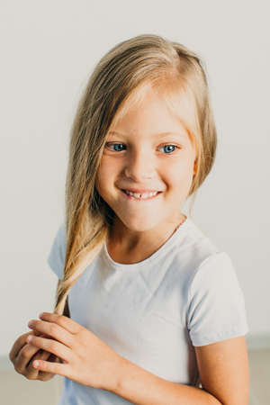 Beautiful little blonde girl posing in studio