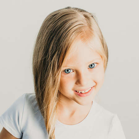 Beautiful little blonde girl posing in studio