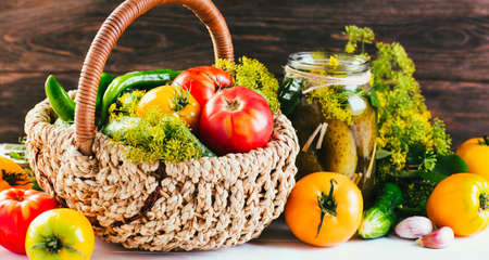 Harvesting seasonal vegetables, cucumbers, tomatoes, peppers and spices on a wooden backgroundの写真素材