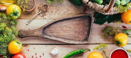 Harvesting seasonal vegetables, cucumbers, tomatoes, peppers and spices on a wooden backgroundの写真素材