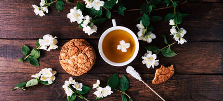 Cup of tea with jasmine and cookies on a wooden background. Long bannerの写真素材
