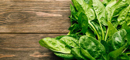 Fresh spinach on a wooden background. Greenery