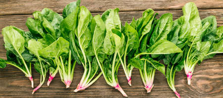 Fresh spinach on a wooden background. Greenery