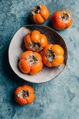 Fresh ripe persimmon on blue backgroundの写真素材