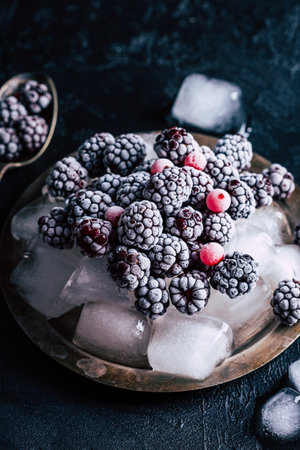 Frozen blackberries on a plate with ice. High quality photo