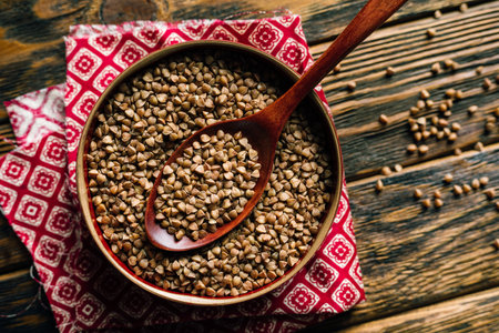 raw buckwheat in a bowl on a wooden background, top view. High quality photoの写真素材