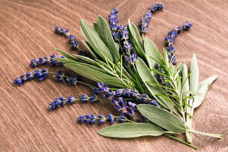 Sage leaves, lavender and rosemary on a wooden background. Fresh spicy herbs.の写真素材