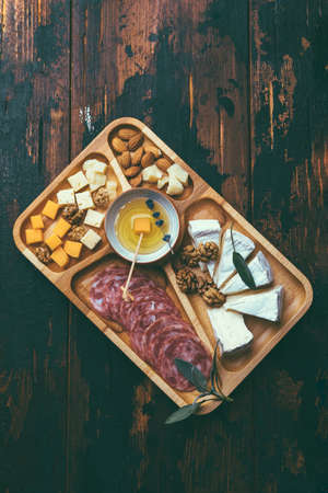 Wine snacks. Assorted cheese on a wooden board.の写真素材