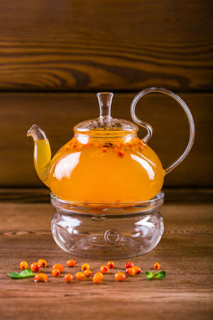 Delicious sea buckthorn tea in a glass teapotの写真素材
