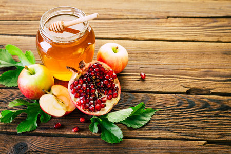 honey, apples and pomegranate on the wooden tableの写真素材