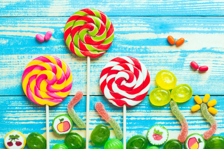 Colorful lollipops and jelly candies on blue wooden backgroundの写真素材