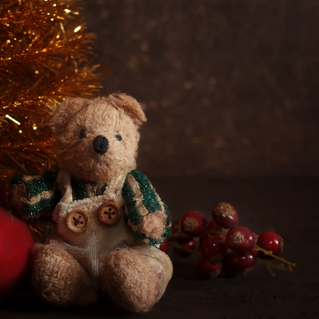 Christmas arrangement with a teddy bear and gifts near golden firの写真素材
