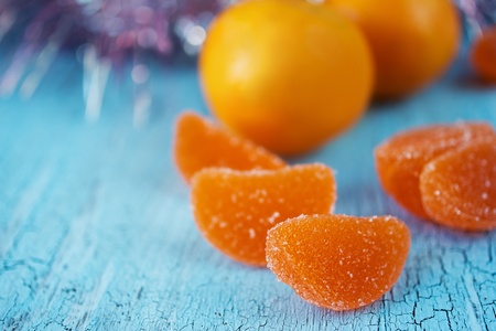 Tangerines and marmalade candies on olden blue woodの写真素材