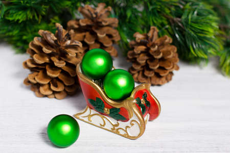 Christmas sleigh with green balls on rusty white backgroundの写真素材