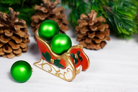 Christmas sleigh with green balls on rusty white backgroundの写真素材