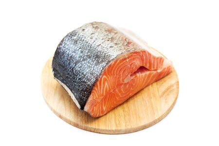 Fresh salmon on a round cutting board, isolated on whiteの写真素材