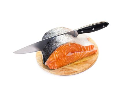 Cutting fresh salmon on a round cutting board, isolated on whiteの写真素材