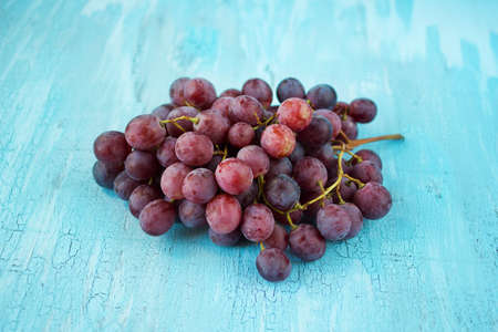 Bunch of ripe red grape on rusty woodの写真素材