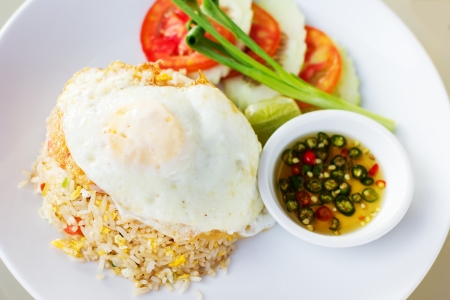 Thai fried rice with egg  Khao phat , served with vegetables and chili oilの写真素材