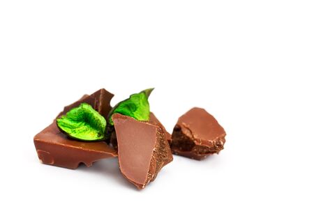 Chocolate pieces on a white background, with green decorの写真素材