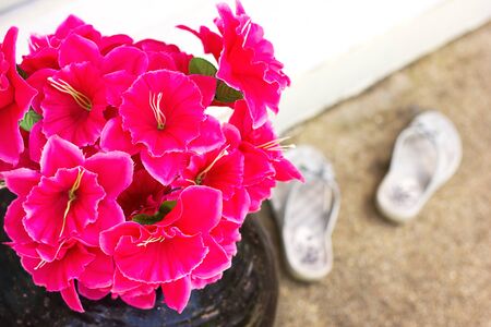 Pink artificial flowers near entranceの写真素材