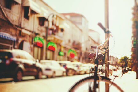 Blurred image of city street with bicycle at sunset with vintage filter effectの写真素材