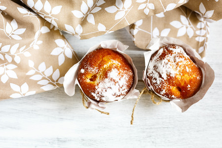 Fresh homemade muffin cakes for breakfast  in paper cupcake holders. Top view.