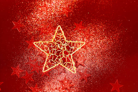 Holiday background with abstract red glitter decoration with big golden star in the centerの写真素材