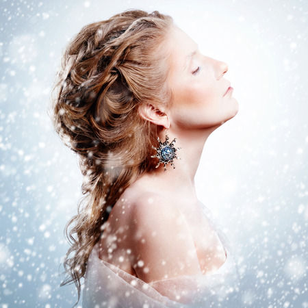 Creative woman portrait in vintage style. Beautiful glamour model girl standing under snowfall with closed eyes. Christmas fashion makeup and hairstyle. Snow queen. Marie Antoinette style.の写真素材