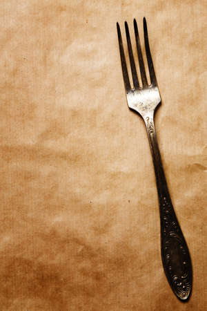 Old fork on craft paper background. Vintage silverware.の写真素材