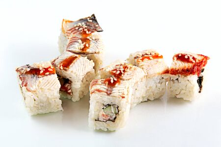 Japanese food. Roll with eel, salmon and cucumber. Eight pieces, over white. Selective focus.の写真素材