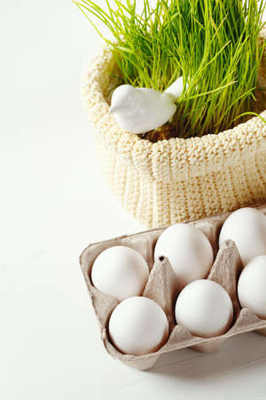 Easter background with eggs in the box and cute bird in green grass at the back. Selective focus,...