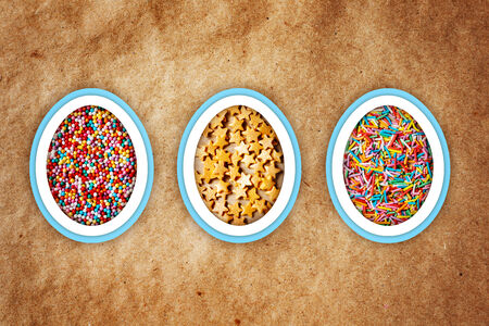 Colorful easter background with different sweet sprinkling on craft paper background. Holiday treat.の写真素材