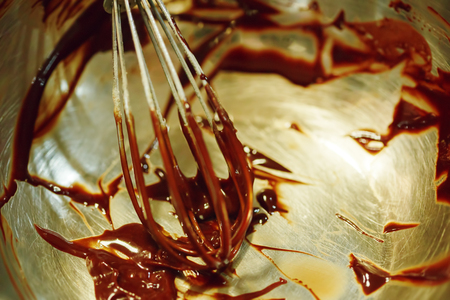 Kitchen Whisk in Bowl with Chocolate. Cooking Cakes. Selective focus, shallow DOF.の写真素材
