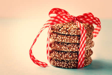 Stacked Chocolate Crispy Cookies with Sesame Decorated with Red Ribbon. Close up, Selective Focus.の写真素材