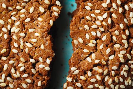 Healthy Fresh Baked Cookies with Sesame cracked on Two Halves on Blue Background. Close up.の写真素材