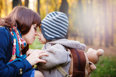 Young Happy Mother Talking to Son while Walking in the Park at the Day. Close up Portrait of Family. Copy Space for Text.の写真素材