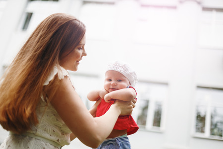 Portrait of Loving Young Mother Holding and Kissing Her Baby. Close Up Composition. Selective Focus on Mother`s Face.の写真素材