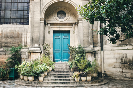 Old Turquoise Door with Stairs and Flower Pots on Both Sides. Ancient Church Wall with Architecture Details..の写真素材