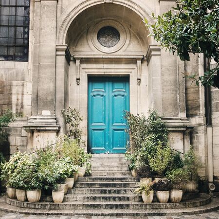 Old Blue Door Step with Stairs and Flower Pots on Both Sides. Ancient Wall with Architecture Details. Image Toned.の写真素材