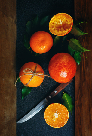 Still Life with Ripe Juicy Citrus Fruits Ready for Eat. Whole, Half and Squeezed Oranges. Vibrant Colors, Vertical Composition. Selective Focus.の写真素材