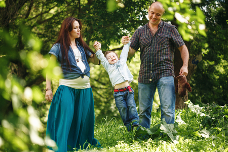 Happy Family Having Fun Outdoors. Young Parents Playing with Their Son. Family Clothing Style. Natural Colors.の写真素材