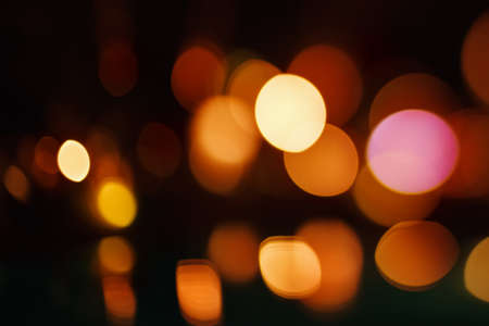Beautiful Bokeh Lights on Dark Background. Defocused Blurred City Lights. Yellow and Red Colors.の写真素材